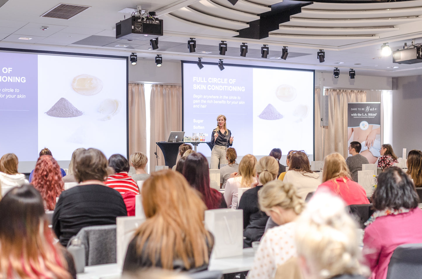 image of Lina giving a presentation to a full room in Finland